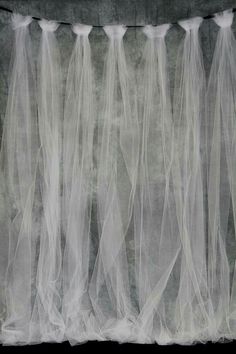 three white veils are hanging from the ceiling in front of a black and white background