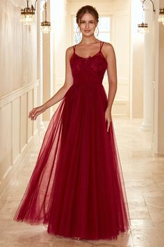 a woman in a long red dress posing for the camera