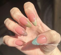 a woman's hand with some pink and green nails