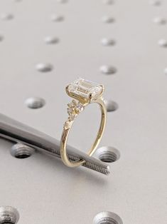 a diamond ring sitting on top of a piece of metal