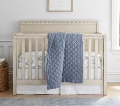 a baby crib with a blue blanket on it