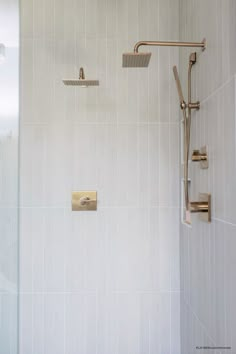 the shower head is mounted on the wall next to the shower faucet in the bathroom