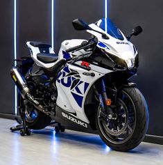 a white and blue motorcycle parked in front of a wall