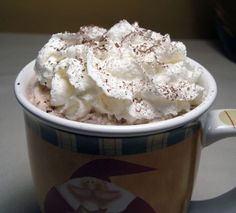 a cup filled with whipped cream on top of a table