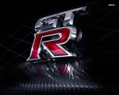 the letter r is illuminated in red and silver on a shiny surface with black background