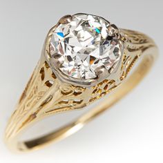 an old - fashioned diamond ring with filigrees is shown in yellow gold