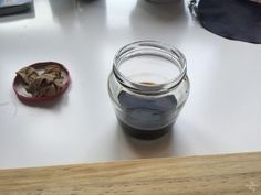 a glass jar filled with liquid sitting on top of a table