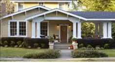 a yellow house with white trim and black shutters on the front door is shown