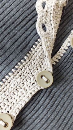 there is a knitted tie with buttons attached to the necktie that has two holes in it