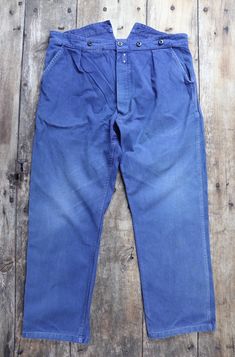 A pair of French blue cotton twill trousers, dating from the late 1940s or early 1950s. Noted flaws - uneven faded colour throughout, particularly at the knee/thigh areas, some wear and fraying at the ankle cuffs and pocket entries, fault in the fabric at the front right upper thigh area, missing one of the front left suspender buttons - please see photos. Freshly laundered, button fly, suspender buttons, pronged buckle back fastening and fishtail detail at the back, two hand pockets, small chan Twill Trousers, Trousers Pants, Ankle Cuffs, Pocket Bag, Trouser Pants, Work Pants, Cotton Twill, Work Wear, Gender Neutral