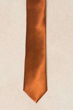 Our charming Mens Max Tie is back, now available in a luxurious amber satin fabric. Just in time for fall weddings. The self-tie style allows for a comfortable fit every time. Perfect for any occasion, this tie is sure to elevate your look. Elegant Solid Color Neckwear For Weddings, Elegant Neckwear For Wedding, Classic Satin Ties For Wedding, Elegant Orange Suit And Tie Accessories For Formal Occasions, Elegant Wedding Suit And Tie Accessories With Adjustable Ties, Elegant Formal Ties, Elegant Satin Neckwear For Formal Occasions, Classic Formal Suit Accessories With Adjustable Ties, Silk Fitted Suit And Tie Accessories For Wedding