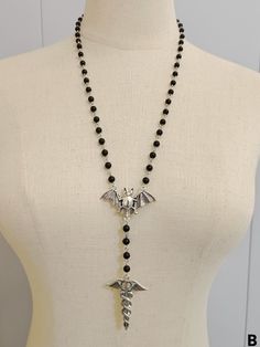 Complete your gothic look with our black gothic bat necklace with beads! This stunning necklace features a bat design adorned with intricate beads, adding a touch of mystery and elegance to any outfit.   Please note that this product includes only the necklace. Gothic Adjustable Necklace For Halloween, Gothic Halloween Adjustable Necklace, Adjustable Gothic Necklace For Cosplay, Black Metal Necklace For Cosplay, Adjustable Black Vampire Style Necklaces, Adjustable Black Vampire Necklace, Black Necklace For Halloween Cosplay, Adjustable Vampire Necklace For Halloween, Gothic Black Beads Jewelry For Halloween