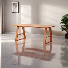 a wooden table sitting on top of a white floor next to a potted plant