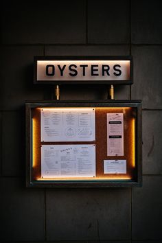 there is a sign that says oysters on the side of a wall with notes attached to it