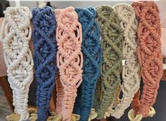 crocheted headbands are lined up on a chair in a row, all different colors