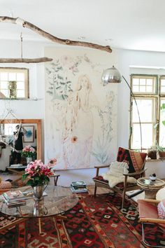 a living room filled with lots of furniture next to a large painting on the wall