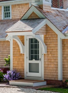 a small wooden house with a white door and windows