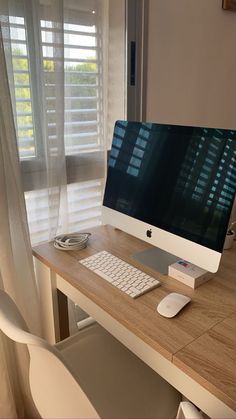 a computer monitor sitting on top of a wooden desk next to a keyboard and mouse