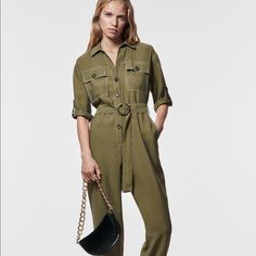 Lapel Collar Jumpsuit With V-Neck And Short Sleeves With Button Tabbed Cuffs. Front Pockets. Tonal Belt And Contrasting Topstitching Detail. Cuffed Hem. Front Button Closure. Brand New With Tags V-neck Jumpsuits And Rompers With Pockets For Work, Office Jumpsuits And Rompers With Pockets For Spring, Casual Office Jumpsuits And Rompers With Pockets, Utility Jumpsuits And Rompers For Summer Workwear, Khaki Utility Jumpsuits And Rompers For Workwear, Khaki Utility Jumpsuit For Work, Utility Style Khaki Jumpsuit For Work, Spring Workwear Pantsuit With Button Closure, Fall Office Jumpsuits And Rompers With Pockets