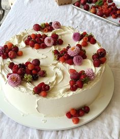 a white cake with strawberries and flowers on it