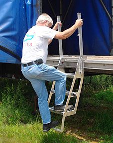 an older man climbing up the side of a truck ladder