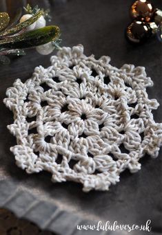 a crocheted doily sitting on top of a table next to other decorations