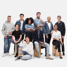 a group of people sitting and standing next to each other in front of a white background