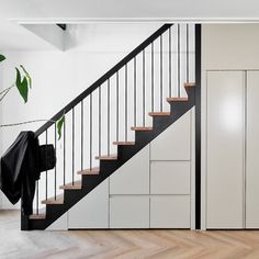 a black and white stair case next to a wooden floor