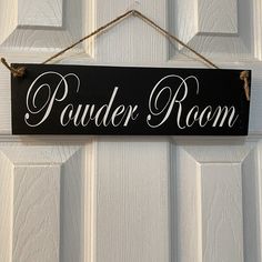 a sign hanging on the front door of a house that says powder room with white lettering