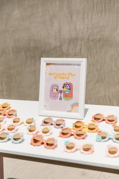 a table topped with lots of buttons next to a white framed photo on top of it