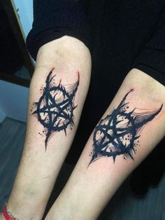 two black ink tattoos on both legs