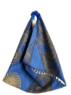 Large sized triangle tote bag with boxed corners, very versatile Origami Bento Bag.  Fully lined, Fabric is an African print in blues and golds.   Interior is  a coordinating tan batik fabric.   The bag is big, and I have boxed the corners to give you some depth. These are great to use while traveling as they fold up nicely to store in your suitcase.  Measurements: Bottom width - 17" Drop is about 12" to center This bag is completed and ready to ship from my smoke free, pet free environment. As with all of my creations, they are handmade by me—from choosing fabric, to the cutting table, on to the sewing machine, pressing, back to sewing machine  then packed for shipping--every step is completed with my two hands.  All bags are hand-washable. This bag should be able to launder in cold water Triangle Tote, Bento Bag, Choosing Fabric, Bento Bags, Batik Fabric, Folded Up, African Print, Sewing Machine, Batik