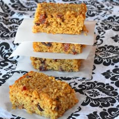 three pieces of granola sitting on top of each other in front of a black and white tablecloth