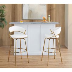 two white bar stools sitting in front of a counter