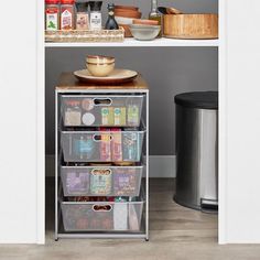 an open pantry with food and drinks on the shelves, next to a trash can