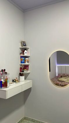 a bathroom with a sink, mirror and shelves on the wall next to each other