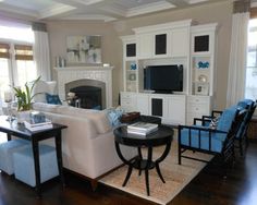 a living room filled with furniture and a flat screen tv mounted on a wall above a fireplace