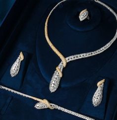 Luxury jewellery on dark blue background. On the foreground are two necklaces decorated with diamonds, one is silver and the other is gold. There are also earrings and rings that form part of the same design. The jewellery looks elegant and is of high value. They are suitable for special occasions or as a luxury gift. Luxury Bridal Necklace, Dubai Luxury, Bridal Necklace Set, Wedding Jewelry Set, Copper Style, Engagement Party Wedding, Bride Accessories, Fashion Jewelry Sets, Elegant Necklaces