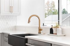 a kitchen with marble counter tops and brass faucets