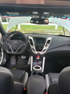 the interior of a small car with black leather seats and steering wheel, dashboard, dash board