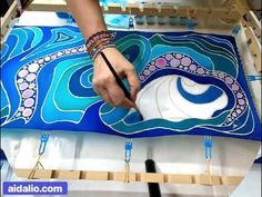 a person is painting an octopus on a blue and white background with watercolors