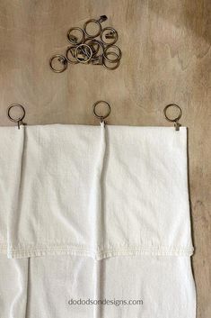 a pair of scissors hanging on the side of a piece of white linen with metal handles