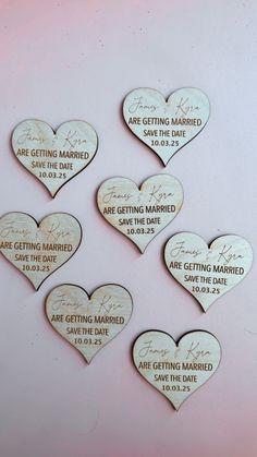 five wooden hearts with names and date printed on them