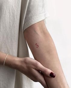 a woman's arm with a small tattoo on the left side of her arm