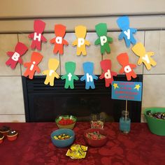 a birthday party is set up in front of a fire place with decorations on the mantle