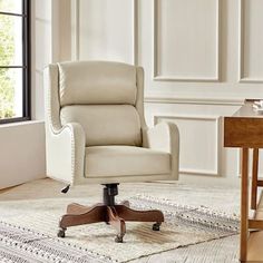 an office chair sitting on top of a rug in front of a window