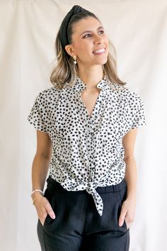 The Sofia blouse features a flowy button-up style with a feminine ruffle collar. Just unbutton the first few buttons, and you've got easy nursing access. For a cropped look, tie the bottom into a knot. Cut from airy cotton, this black and white printed blouse features pretty abstract flowers. A customer's print favorite: available in the Gaelle Wrap Blouse. Size Guide Details Shipping XS - (0) | Bust 32-33 | Waist 24-26 | Hip 34-35 S - (2-4) | Bust 34-35 | Waist 27-28 | Hip 36-37 M - (6-8) | Bus Short Sleeve Tie Waist Tops For Daytime, Spring Blouse With Tie Waist And Short Sleeves, Spring Short Sleeve Blouse With Tie Waist, Spring Tops With Tie Waist And Tie Neck, Spring Workwear Tops With Tie Neck, Tie Waist Short Sleeve Tops For Work, Short Sleeve Tie Waist Tops For Work, Short Sleeve Tops With Tie Waist For Work, Spring Workwear Tie Neck Tops