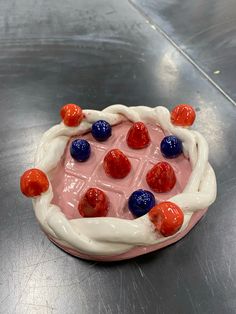 a cake with red, white and blue candies on it's side sitting on a table