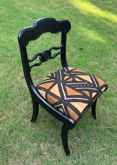 a black chair sitting on top of a lush green field