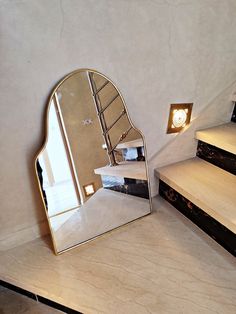 a mirror sitting on top of a counter next to stairs